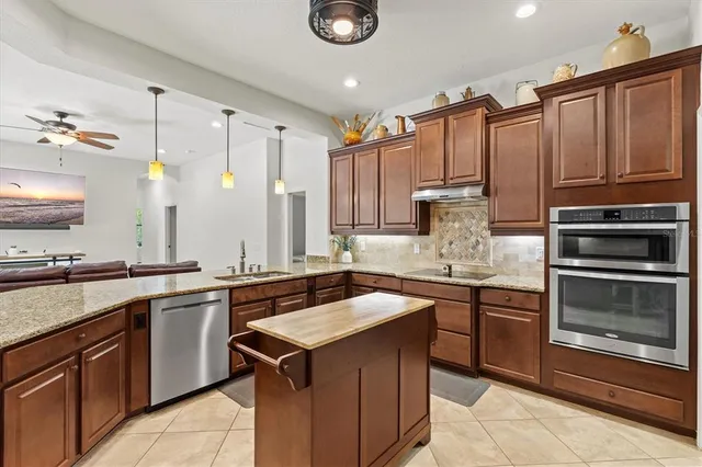 a kitchen with stainless steel appliances granite countertop a sink refrigerator and microwave