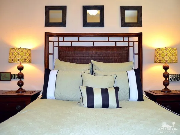 a bedroom with a bed and a flat tv screen on dresser