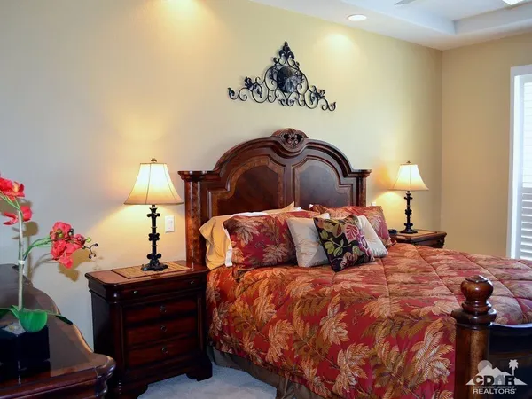 a bed sitting in a bedroom next to a lamp