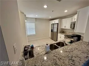 a kitchen with stainless steel appliances kitchen island granite countertop a sink stove and refrigerator