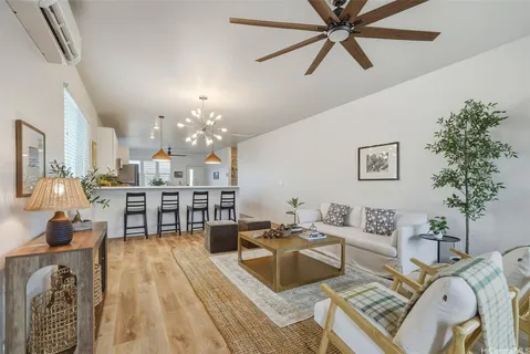 a living room with furniture a dining table with wooden floor and chandelier