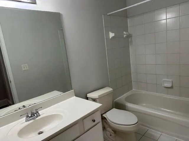a white toilet and tub sitting next to a bathroom sink