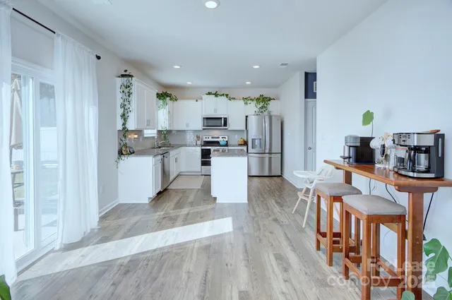 a kitchen with stainless steel appliances kitchen island wooden cabinets and refrigerator
