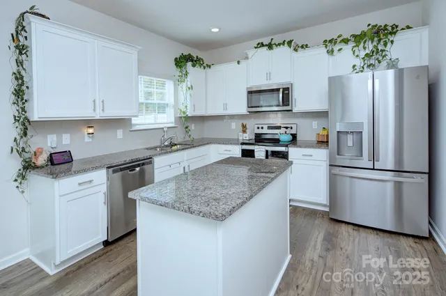 a kitchen with stainless steel appliances granite countertop a refrigerator sink and microwave