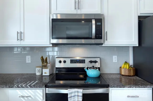 a kitchen with stainless steel appliances granite countertop stove top oven and cabinets