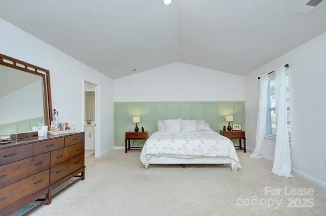 a spacious bedroom with a bed and a dresser