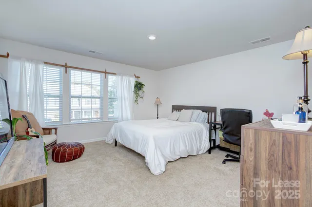 a spacious bedroom with a bed and a couch