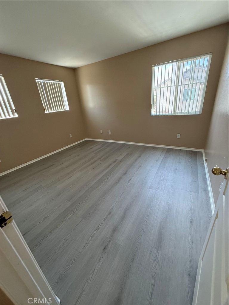 4318-4318 Walnut Street, Unit A Baldwin Park, CA 91706 - Photo 13 of 16 an empty room with wooden floor and windows