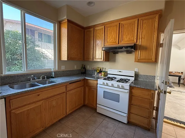 a kitchen with a sink stove top oven and cabinets