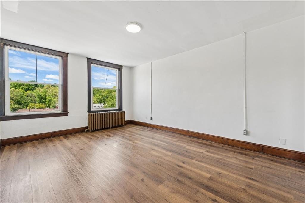 206 North Warren Avenue Apollo, PA 15613 - Photo 5 of 23 an empty room with wooden floor and window