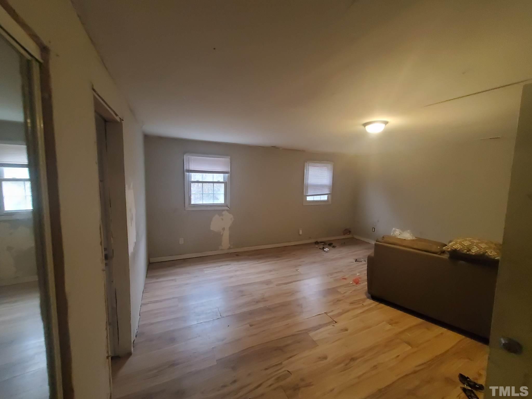 3600 Dearborn Drive Durham, NC 27704 - Photo 6 of 13 an empty room with wooden floor and windows