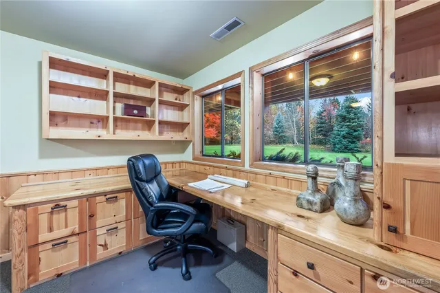 a view of a workspace with furniture and a window
