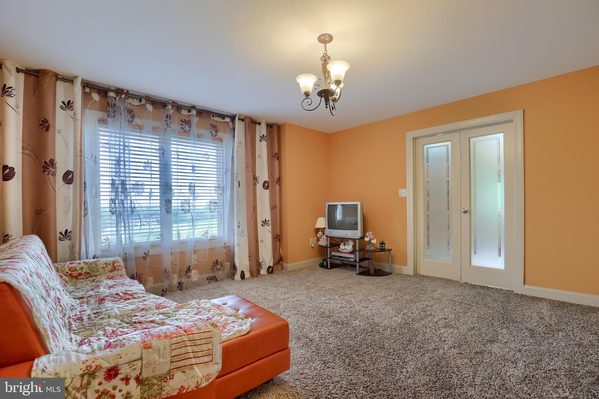 70 Horseshoe Trail Road Denver, PA 17517 - Photo 65 of 128 a bedroom with a bed and a chandelier