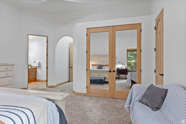 98 Bridge Road Rockville, UT 84763 - Photo 17 of 75 Primary Suite. Carpeted bedroom with french doors, connected bathroom, and arched walkways