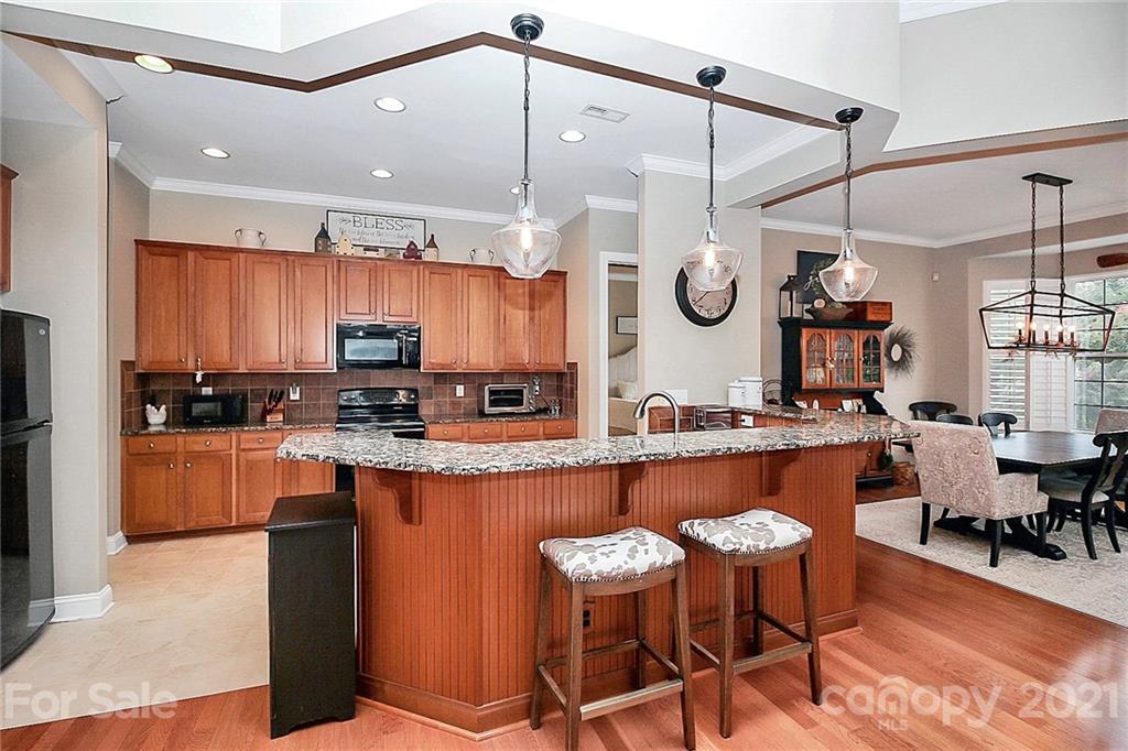 2018 Dynasty Court Fort Mill, SC 29708 - Photo 13 of 31 a kitchen with stainless steel appliances granite countertop a sink a stove a refrigerator and island with wooden floor