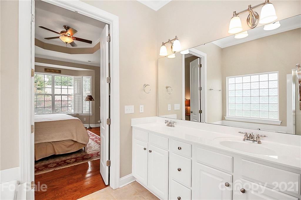 2018 Dynasty Court Fort Mill, SC 29708 - Photo 17 of 31 a en suite bathroom with a double vanity sink a large mirror a bathtub and window
