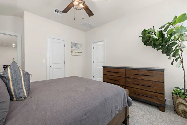 a bedroom with a bed and a potted plant