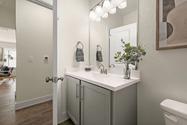 a bathroom with a sink a toilet and mirror