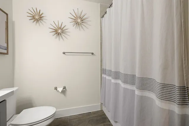 a bathroom with a toilet and a shower