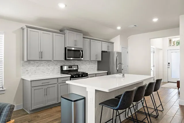 a kitchen with a sink a microwave a refrigerator and cabinets