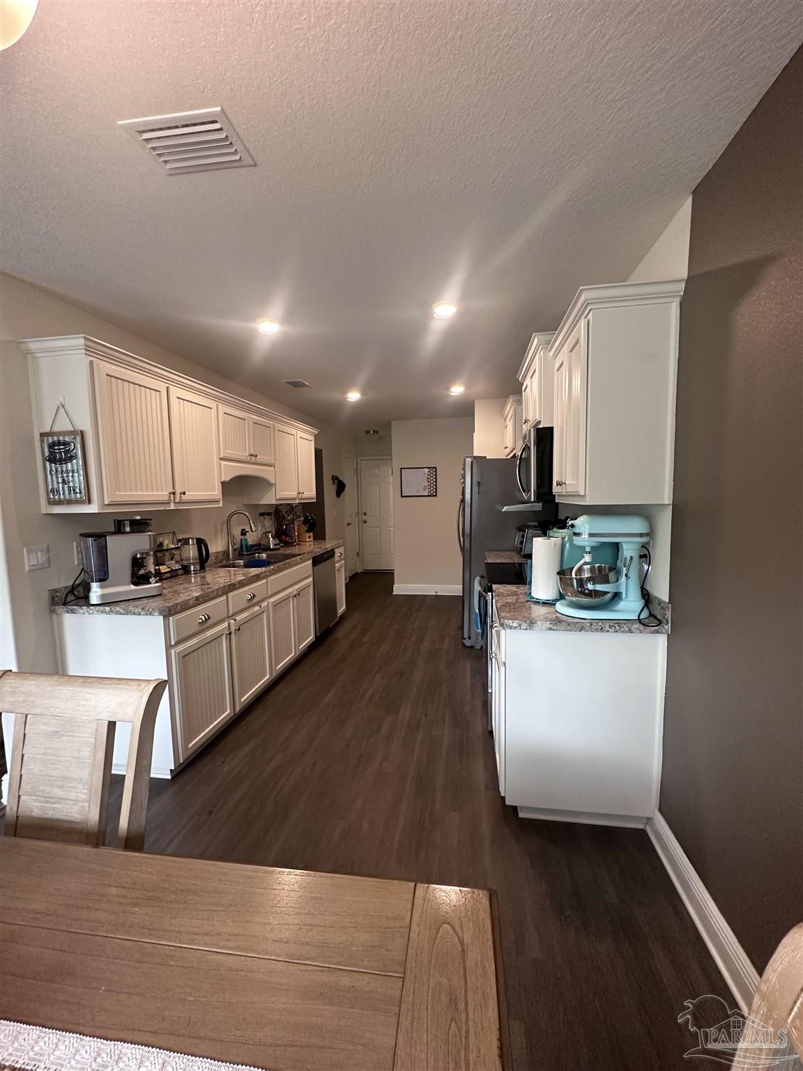5217 Saufley Field Road Pensacola, FL 32526 - Photo 8 of 26 a kitchen with a sink a stove top oven and white kitchen