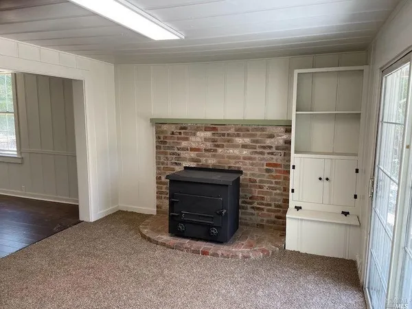 an empty room with a fireplace and window