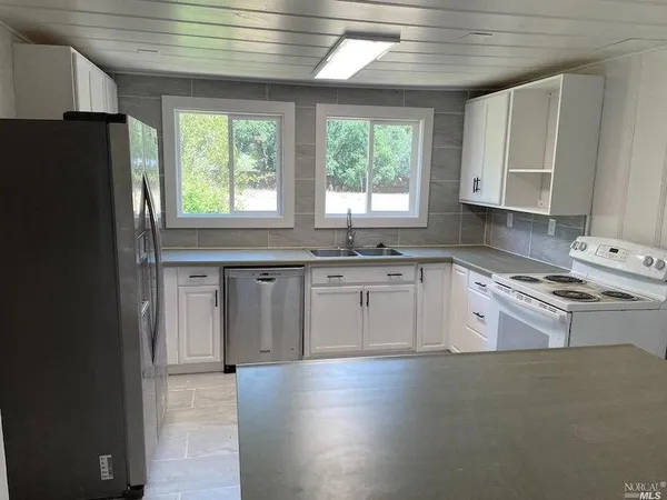 a kitchen with stainless steel appliances granite countertop a stove a sink dishwasher and a refrigerator