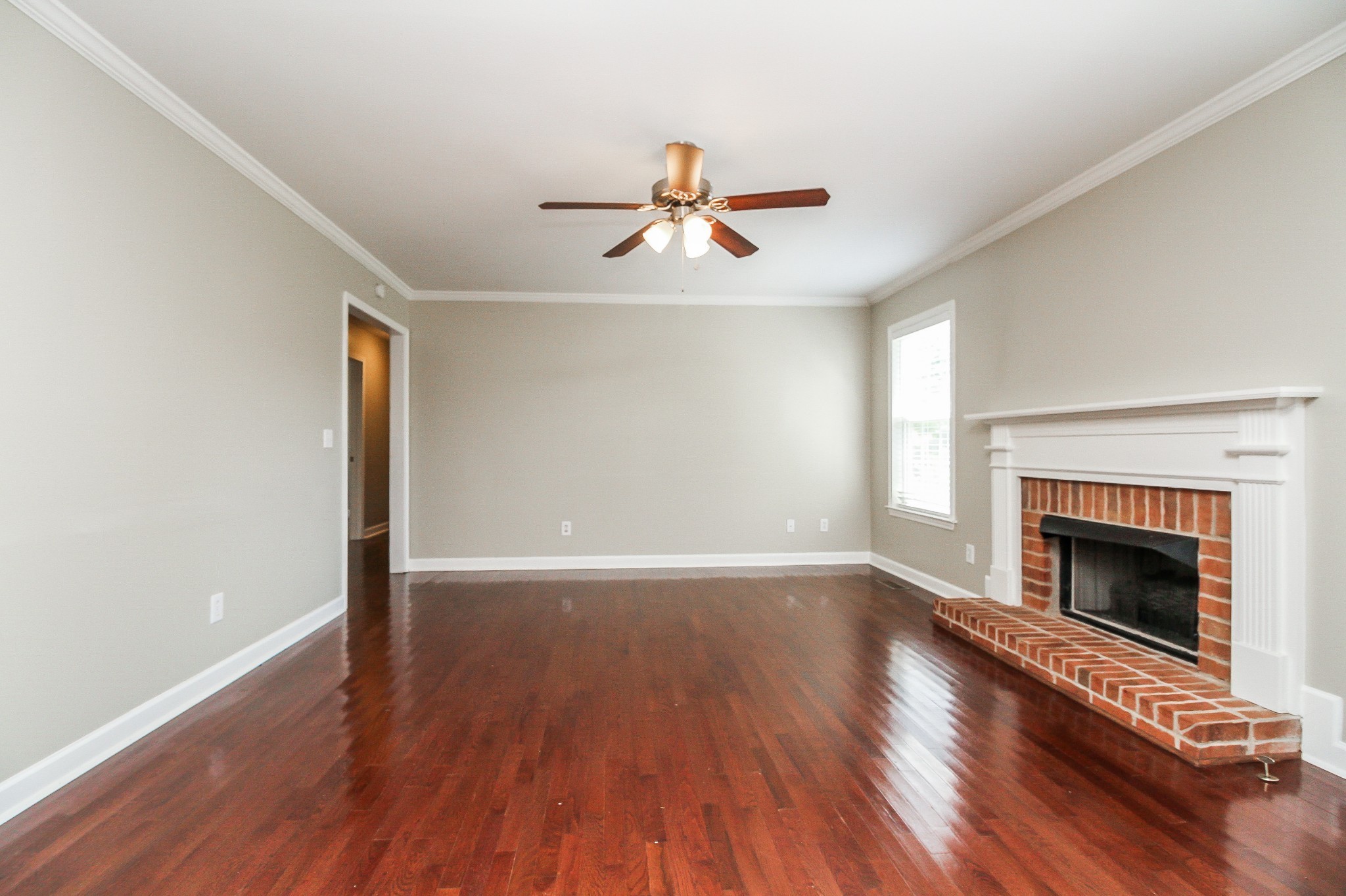 2921 Stapleton Drive Spring Hill, TN 37174 - Photo 2 of 17 an empty room with wooden floor fireplace cabinet and windows
