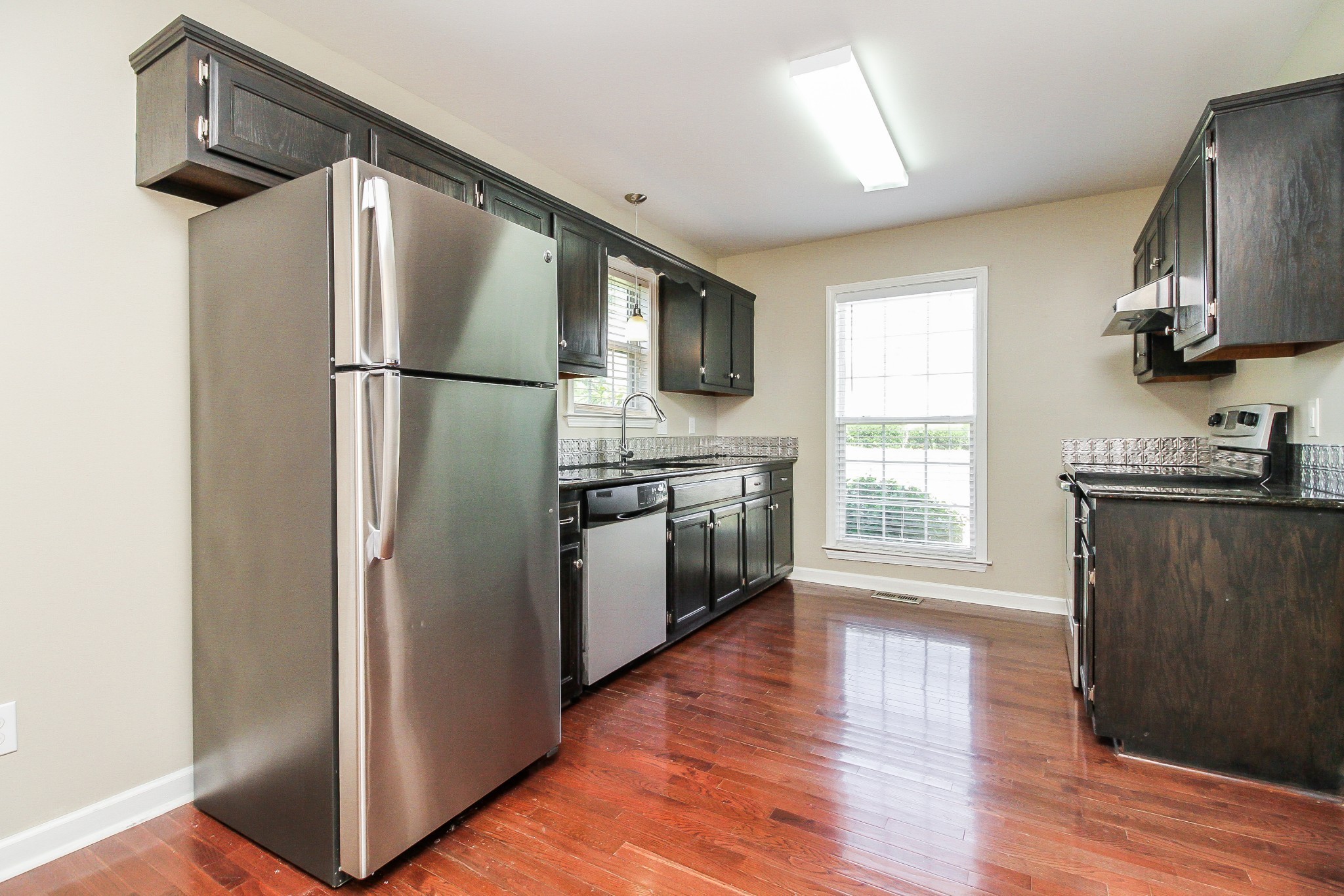 2921 Stapleton Drive Spring Hill, TN 37174 - Photo 6 of 17 a kitchen with stainless steel appliances granite countertop a refrigerator a sink a stove a microwave and wooden floor
