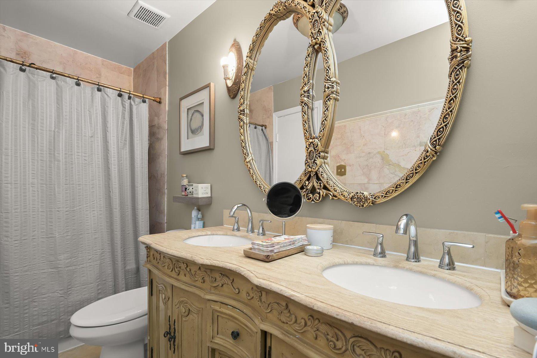 737 St Michaels Drive Bowie, MD 20721 - Photo 26 of 41 a bathroom with a granite countertop toilet a sink and a mirror