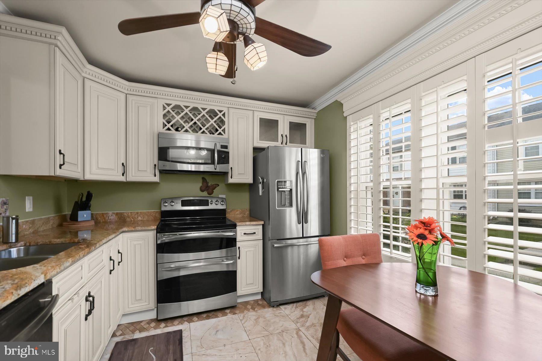 737 St Michaels Drive Bowie, MD 20721 - Photo 5 of 41 a kitchen with stainless steel appliances kitchen island granite countertop a refrigerator a stove a sink dishwasher a dining table and chairs with wooden floor