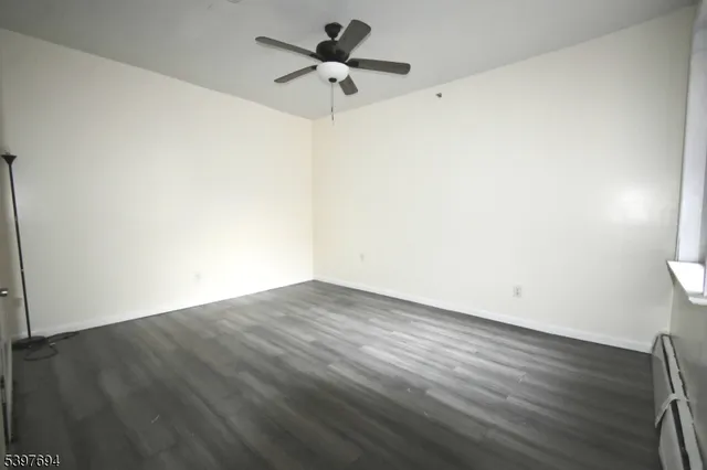 a view of a room with wooden floor and a ceiling fan