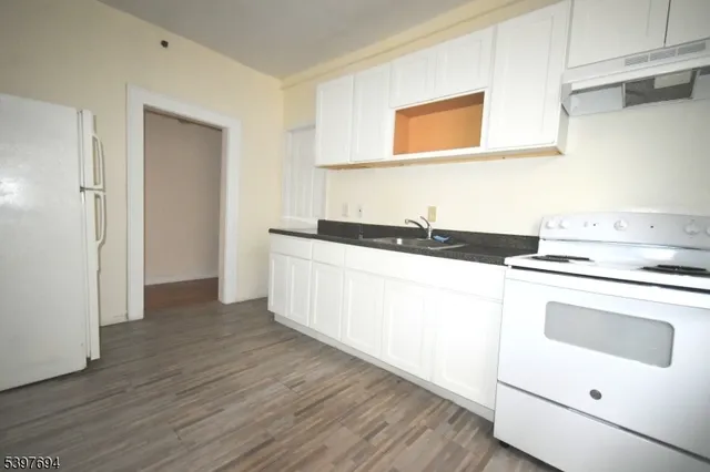 a kitchen with a sink cabinets and wooden floor