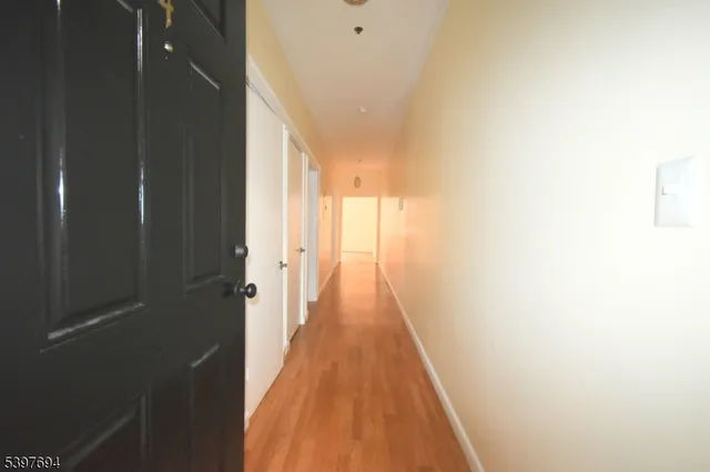 a view of a hallway with wooden floor