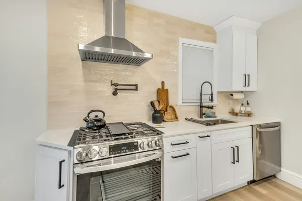 a kitchen with a stove and white cabinets