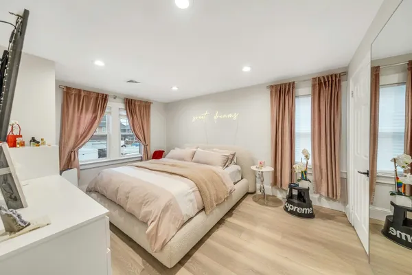 a spacious bedroom with a large bed and a large window
