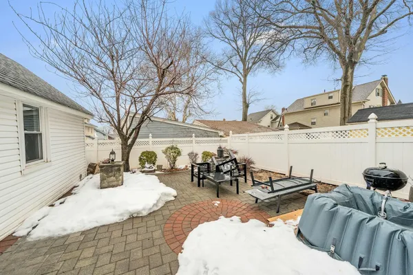 a view of a patio with table and chairs with wooden fence