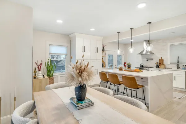 a kitchen with a table chairs refrigerator and microwave