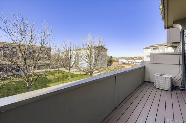 a view of a balcony with wooden floor and fence