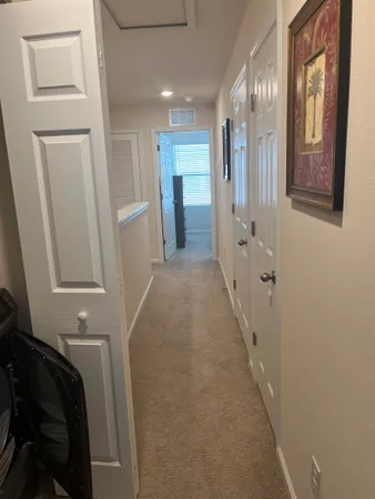 a view of a hallway with wooden floor and staircase