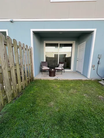 a view of a backyard with table and chairs and wooden fence