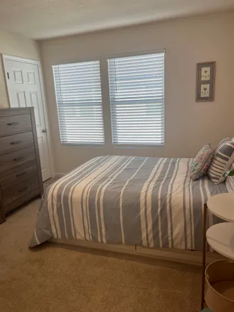 a bed sitting in a bedroom next to a window