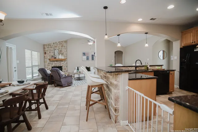 a kitchen with stainless steel appliances kitchen island granite countertop a sink and a refrigerator