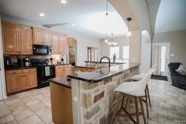 a kitchen with stainless steel appliances kitchen island granite countertop a sink and cabinets
