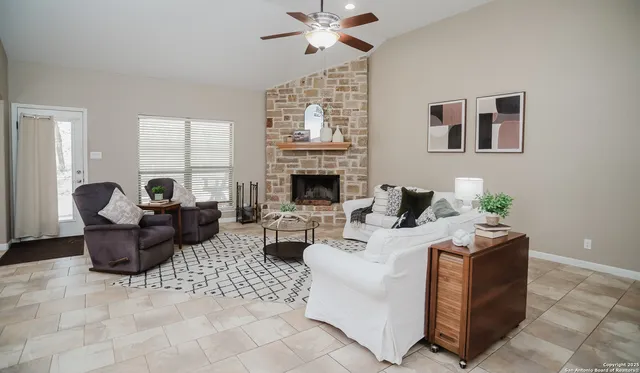 a living room with furniture a fireplace and a chandelier
