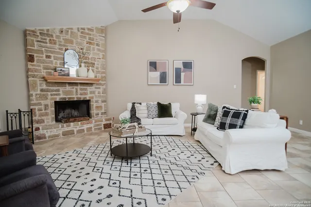 a living room with furniture a fireplace and a chandelier