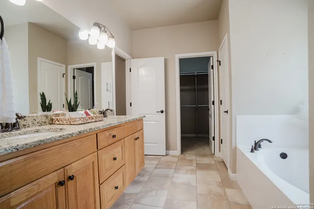 a spacious bathroom with a granite countertop sink tub and shower