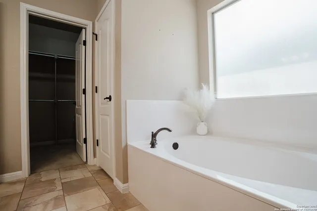 a bathroom with a bathtub and a window
