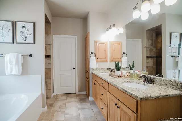a bathroom with a granite countertop sink a large mirror and a bathtub