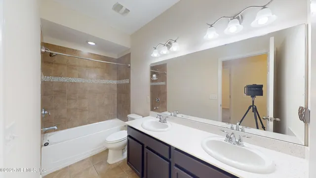 a bathroom with a bathtub shower sink double vanity and toilet